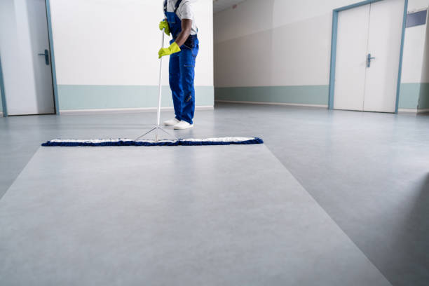 Young Man Cleaning The Floor With Mop In Office